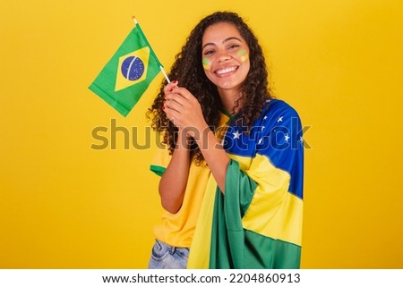 Young black Brazilian woman, soccer fan. waving flag, patriotic, nationalist.