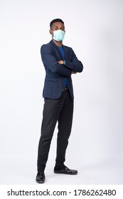 Young Black Business Man Wearing A Suit And Face Mask Standing Confidently With Arms Crossed