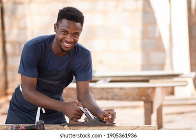 young black carpenter smiling while working