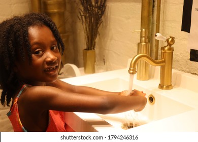 Young Black Child Washing Hands In Upscale Sink Indoors