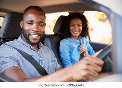 Young Black Couple In A Car On A Road Trip Smiling To Camera