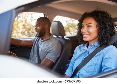 Young Black Couple In Car On A Road Trip Look Ahead Smiling