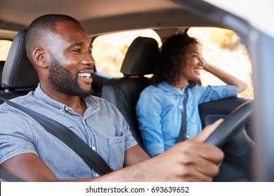 Young Black Couple In Car On A Road Trip Look Ahead Smiling