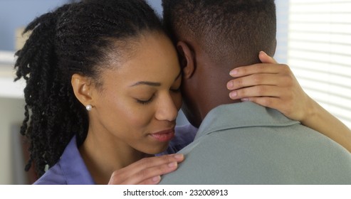 Young black couple embracing and talking to one another