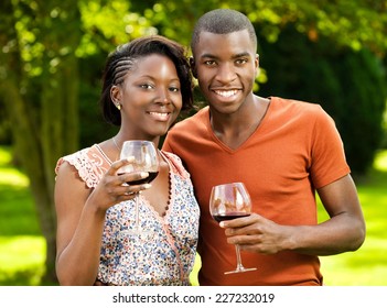 Young Black Couple Enjoying Sunny Day And Drinking Wine In Their Backyard.