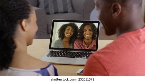 Young Black Couple Having Internet Video Chat With Two Friends On Laptop