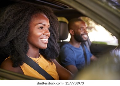 Young black couple smiling in a car during a road trip - Powered by Shutterstock