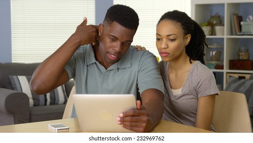 Young Black Couple Talking To Doctor About Neck Pain Over Tablet Computer