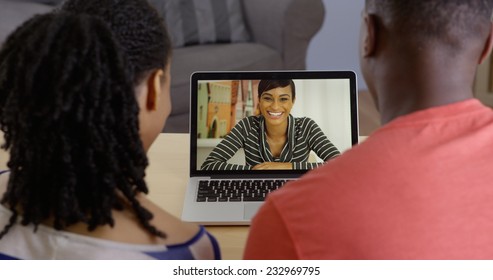 Young Black Couple Talking To Friend Over Laptop Video Chat