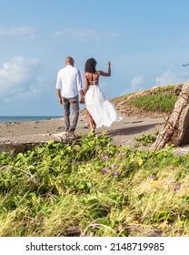 Young black couple walking towards the beach while holding hands. Jamaican couple
