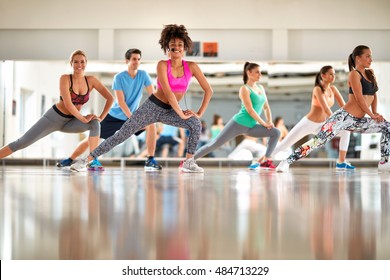 Young black curly trainer with group training aerobic at gym