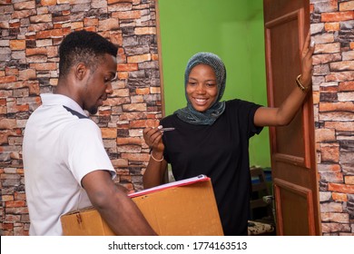 Young Black Delivery Company Worker Makes A Delivery To A Woman, Has Her Sign A Manifest