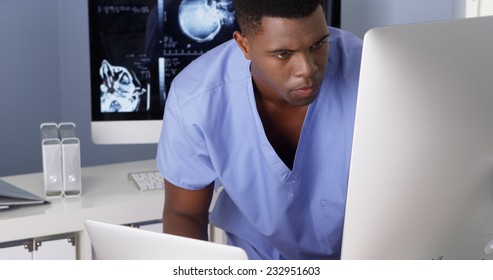 Young Black Doctor Working On Multiple Computers