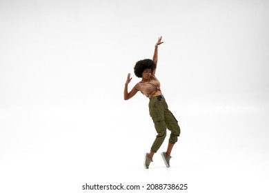 Young black female dancer dancing hip hop dance. Concept of contemporary dancing. Idea of choreography. Confident curly woman looking at camera. Isolated on white background in studio. Copy space - Powered by Shutterstock