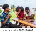 Young black friends eating, hanging out and having fun at outdoor restaurant