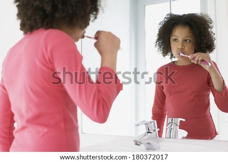 Young black girl brushing her teeth in the  morning.