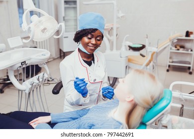 young black girl doctor dentist treats white girl's teeth. - Shutterstock ID 797442691