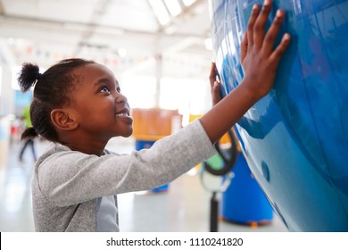 Young Black Girl Holding A Giant Globe At A Science Centre