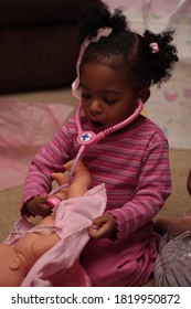 Young Black Girl Playing With Toy Stethoscope And Doll