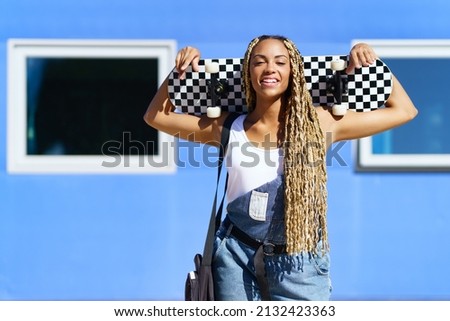 Young black girl smiling with coloured braids. Typical African hairstyle.