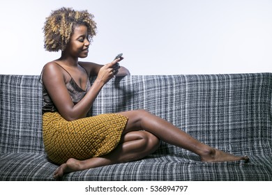 Young Black Girl Talking On The Phone Sitting On The Sofa