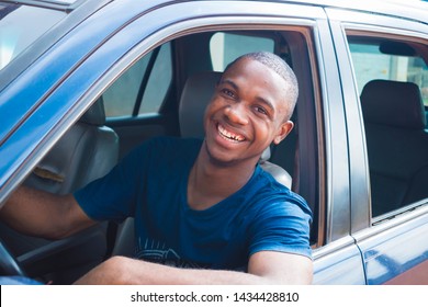 Young Black Handsome Cab Driver Smiling Inside His Blue Car