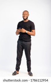 Young Black Handsome Man Standing Texting With His Smartphone With A Smile On His Face