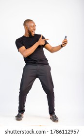 young black handsome man standing jubilating over something he saw on his smartphone