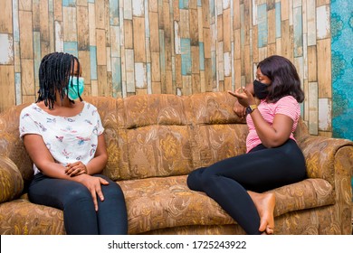 young black ladies sitting on a couch, discussing and making some jokes