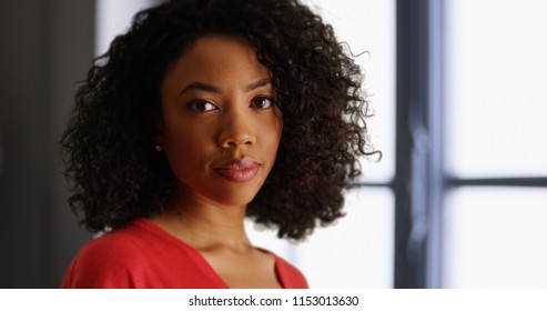 Young black lady deep in thought turning to face camera in indoor setting - Shutterstock ID 1153013630