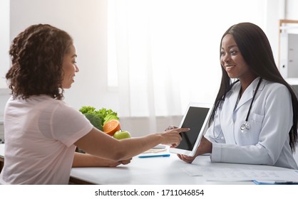 Young Black Lady Doctor Consultating Patient, Client Touching Blank Digital Tablet Screen, Copy Space