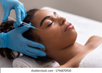 Young Black Lady Receiving Eye Zone Injection At Beauty Salon, Anti-aging Treatment Concept, Closeup