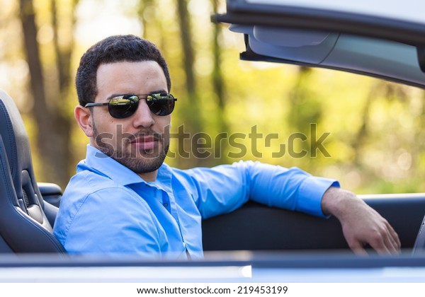 Young\
black latin american driver  driving his new\
car