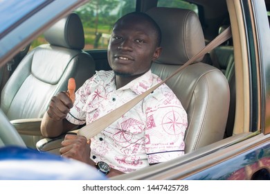 Young Black Male Driver Giving A Thumbs Up While Holding His Seatbelt