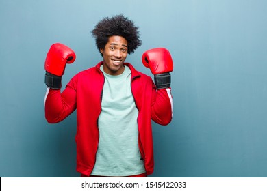 young black man with boxing gloves against blue grunge wall - Powered by Shutterstock