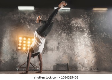 A Young Black Man Break Dancing  In Front Of A Rustic Wall Background