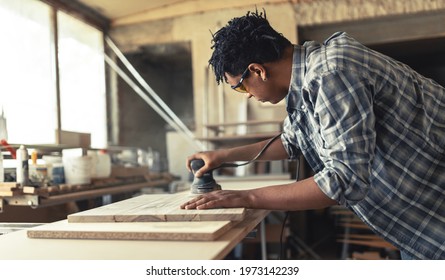 Young Black Man Carpenter Working In His Workshop.