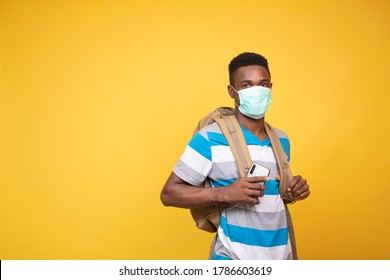 a young black man carrying a backpack and wearing a face mask - Powered by Shutterstock