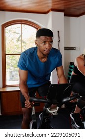 Young Black Man And Caucasian Woman Doing Cardio On Exercise Bike At The Gym