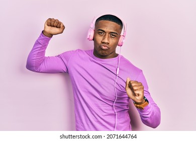 Young Black Man Dancing Listening To Music Using Headphones Looking At The Camera Blowing A Kiss Being Lovely And Sexy. Love Expression. 