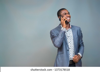 Young Black Man Dressed Corporate Smiling While Making A Phone Call