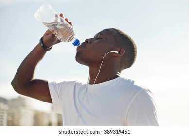 Young Black Man Drinking Water During Exercise.