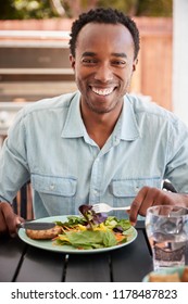 Young Black Man Eating Lunch At A Table Outside, Vertical