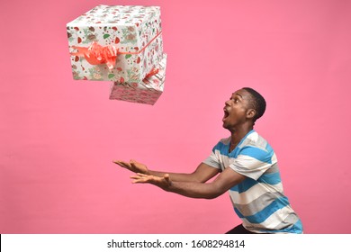 Young Black Man Feeling Excited While Catching Gift Boxes