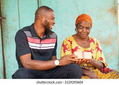 Young Black Man Gives An Old Black Woman A Gift