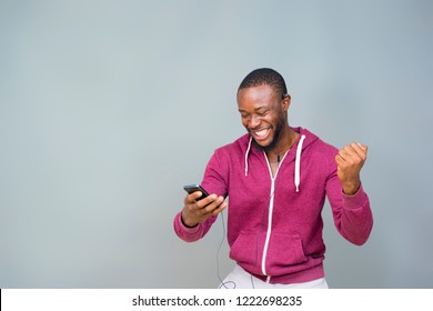 Young Black Man Happy And Excited And Celebrating While Looking At His Mobile Phone 