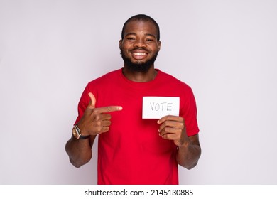 Young Black Man Holding A Card That Says Vote