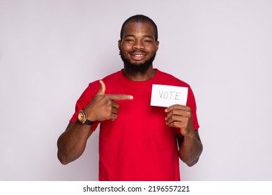 Young Black Man Holding A Card That Says Vote