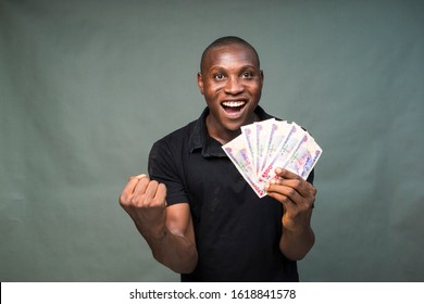 Young Black Man Holding Some Cash, Feeling Happy And Celebrates