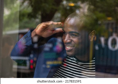 Young Black Man Looking Through The Window